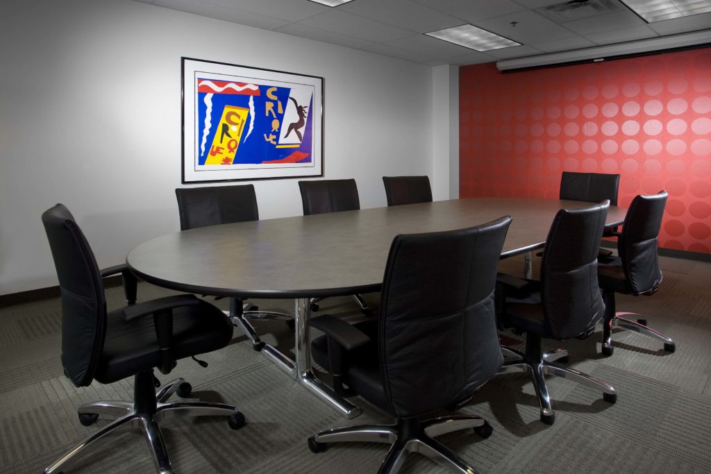 Conference room with black leather chairs and red polka dot wall