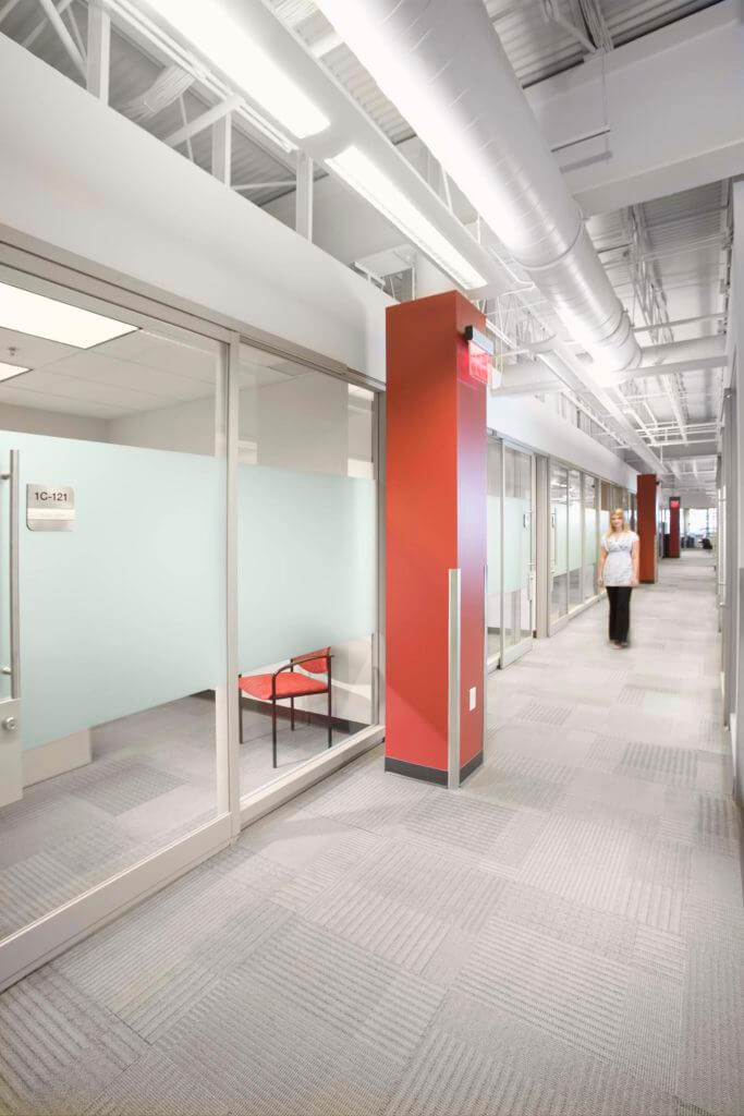 Woman walking down hallway of office space