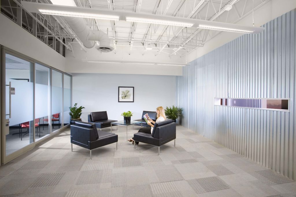 Woman sitting in lobby of business reading a magazine